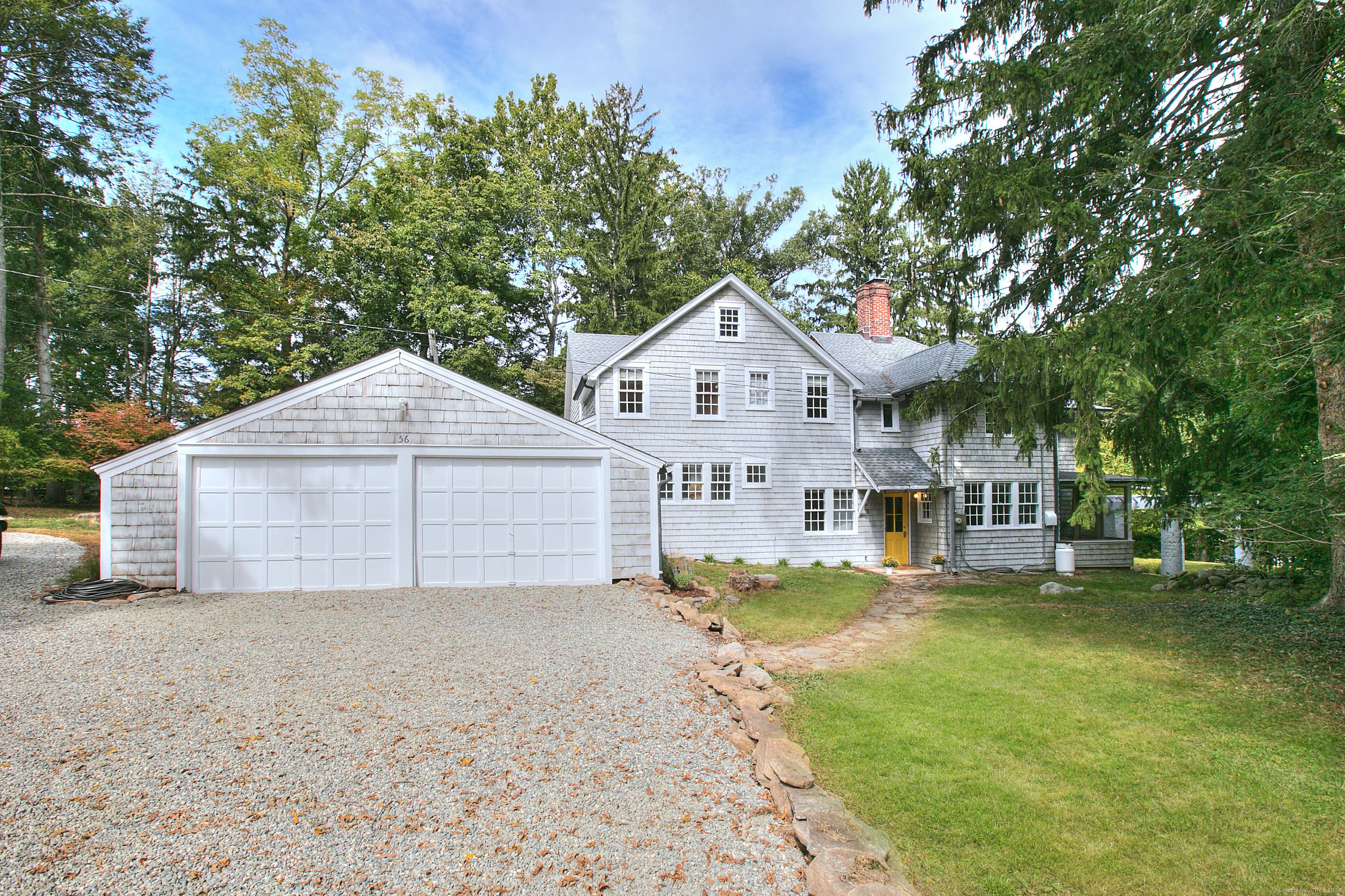 a view of a house with a yard and large trees