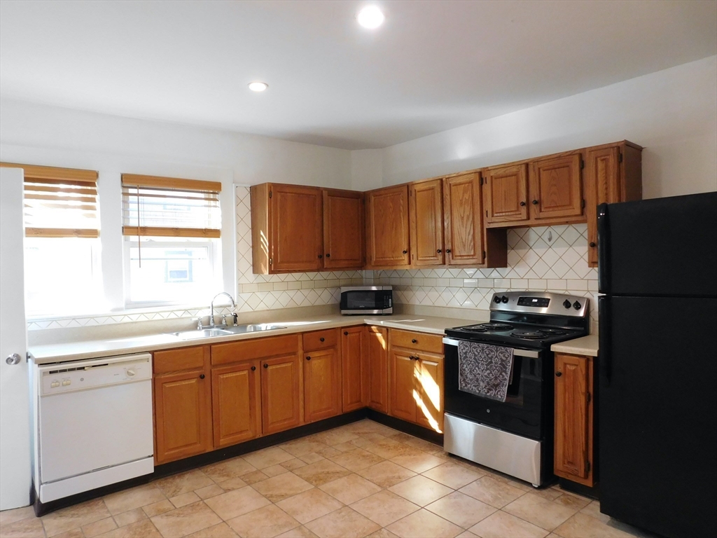 a kitchen with stainless steel appliances granite countertop a stove sink and cabinets