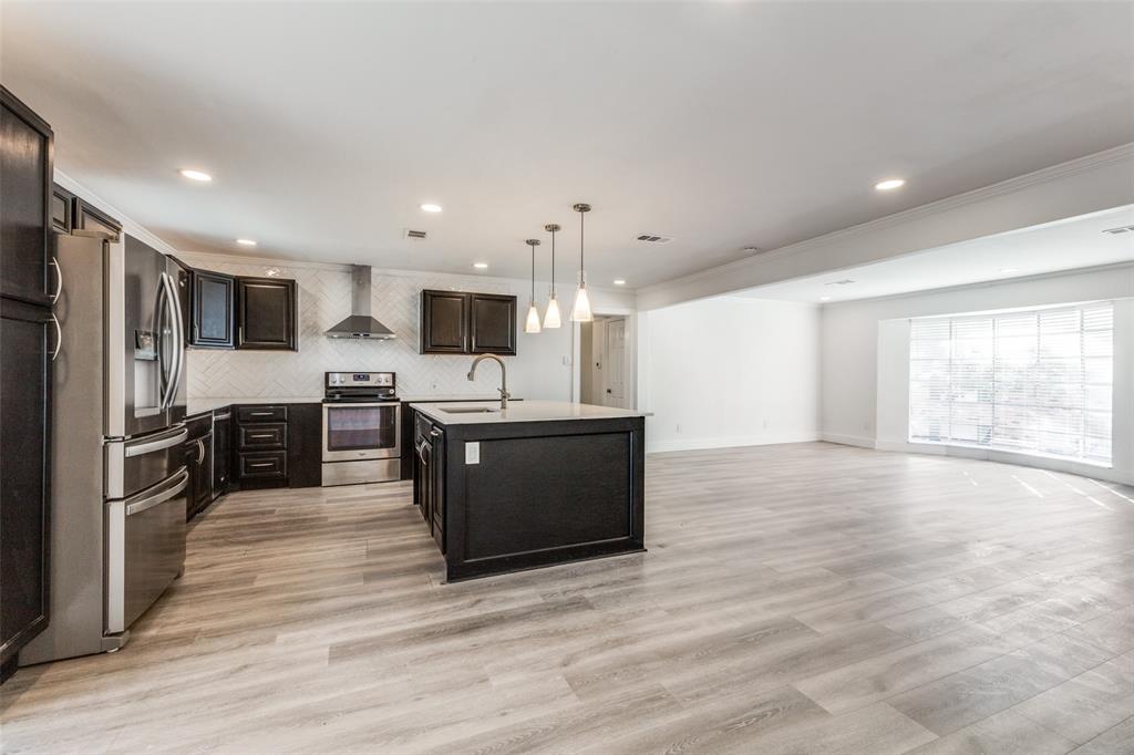 a large kitchen with a large counter top stainless steel appliances and cabinets