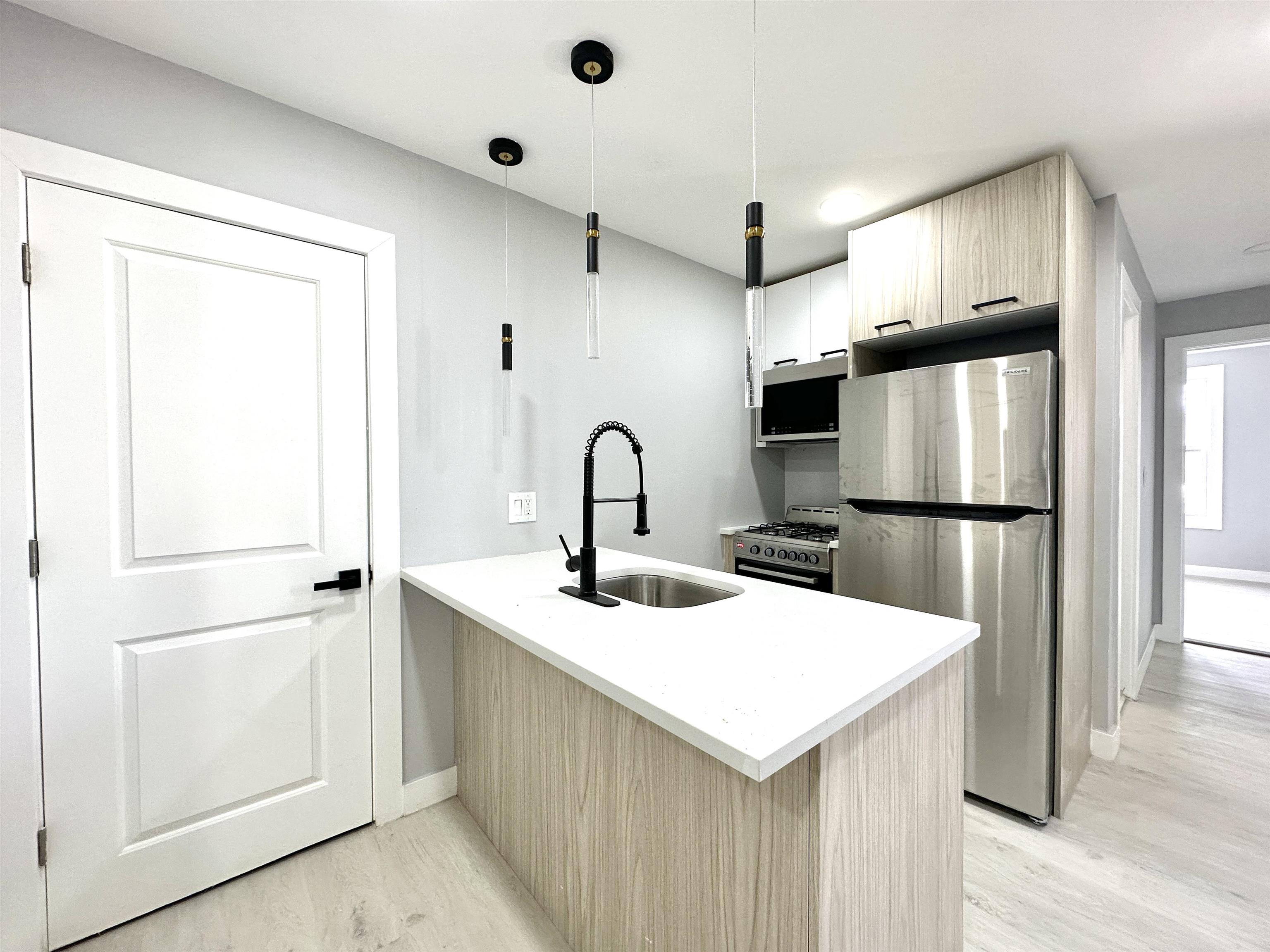 a kitchen with a refrigerator sink and cabinets