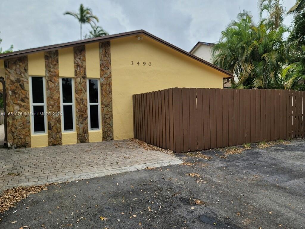 a view of backyard with door and wooden fence