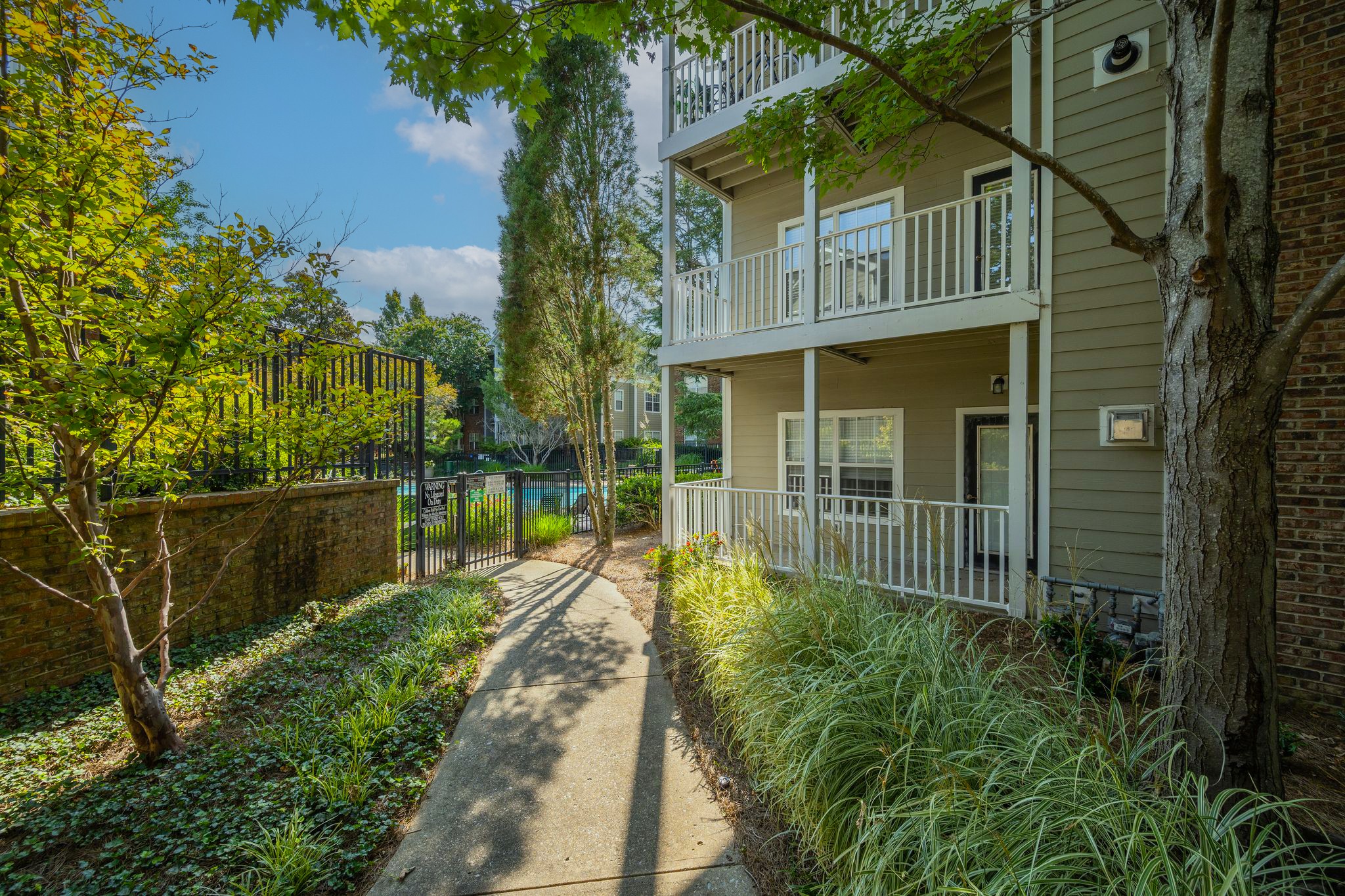 Lush, manicured grounds surround this corner unit home that offers a deck overlooking the central courtyard area & pool