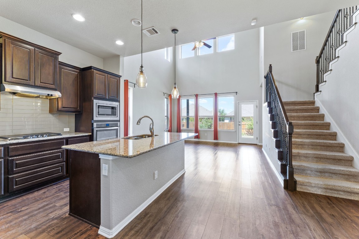 a view of a kitchen with wooden floor and electronic appliances