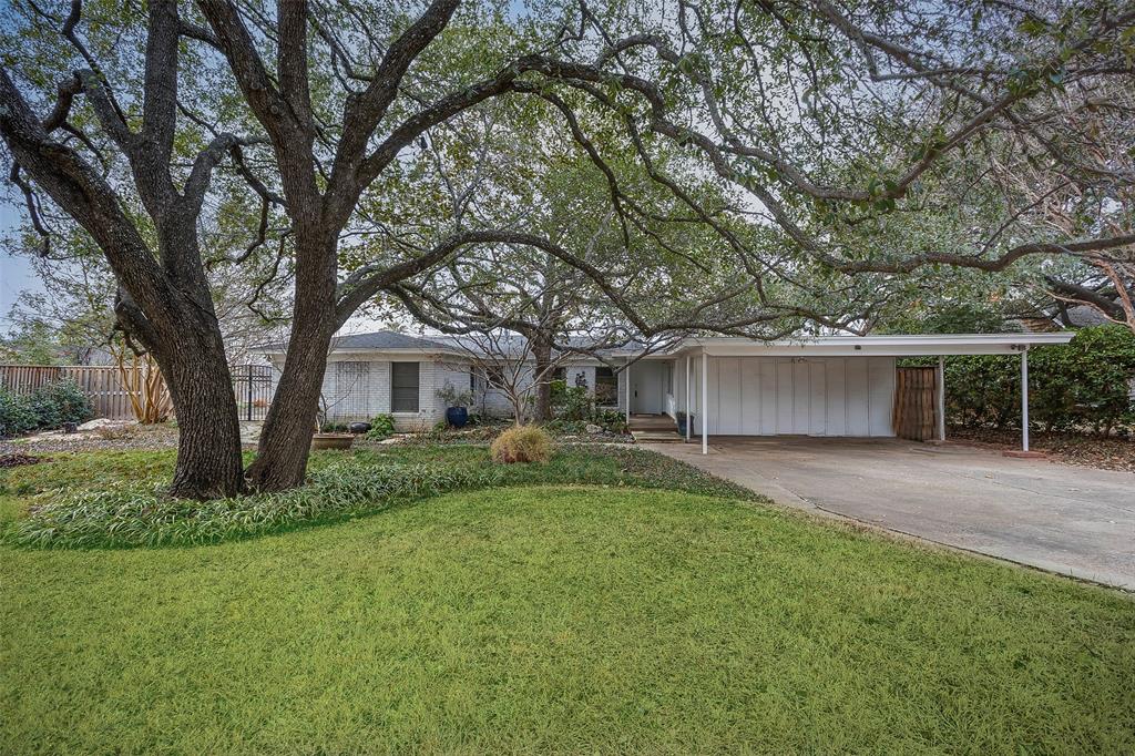 a view of a house with backyard and trees