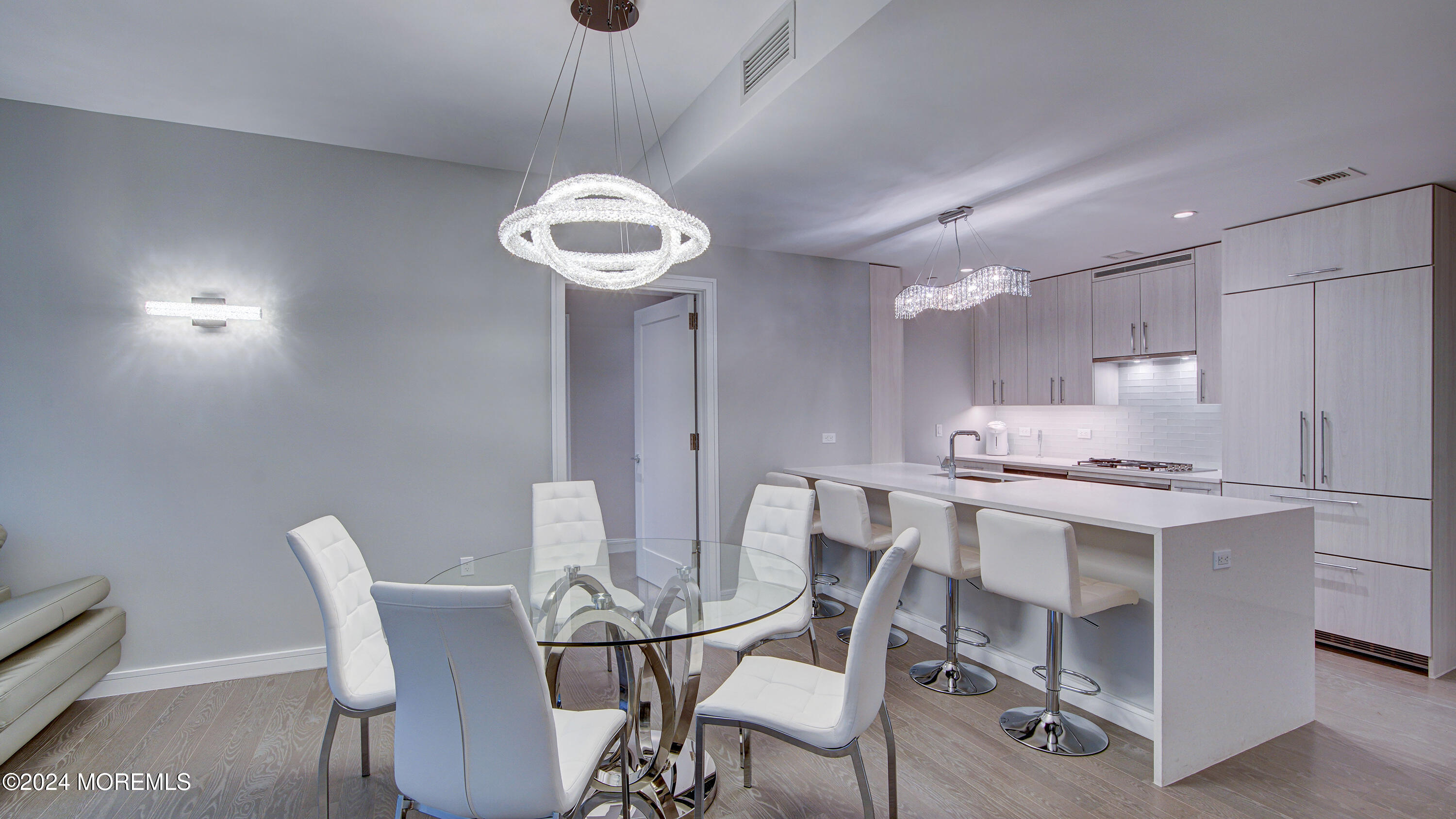 a view of a dining room with furniture a chandelier and wooden floor