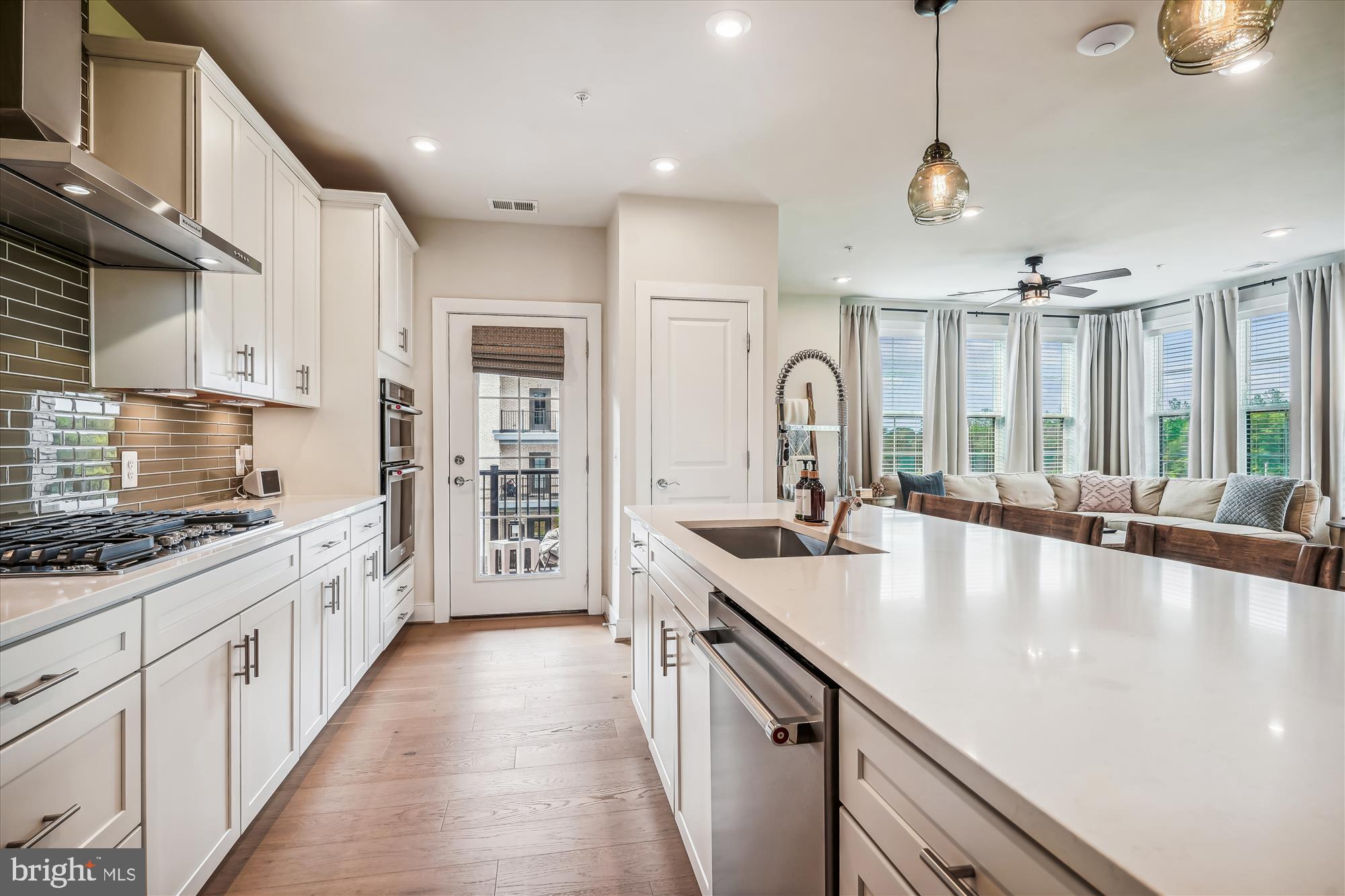 a large kitchen with stainless steel appliances granite countertop a lot of counter space and wooden floors