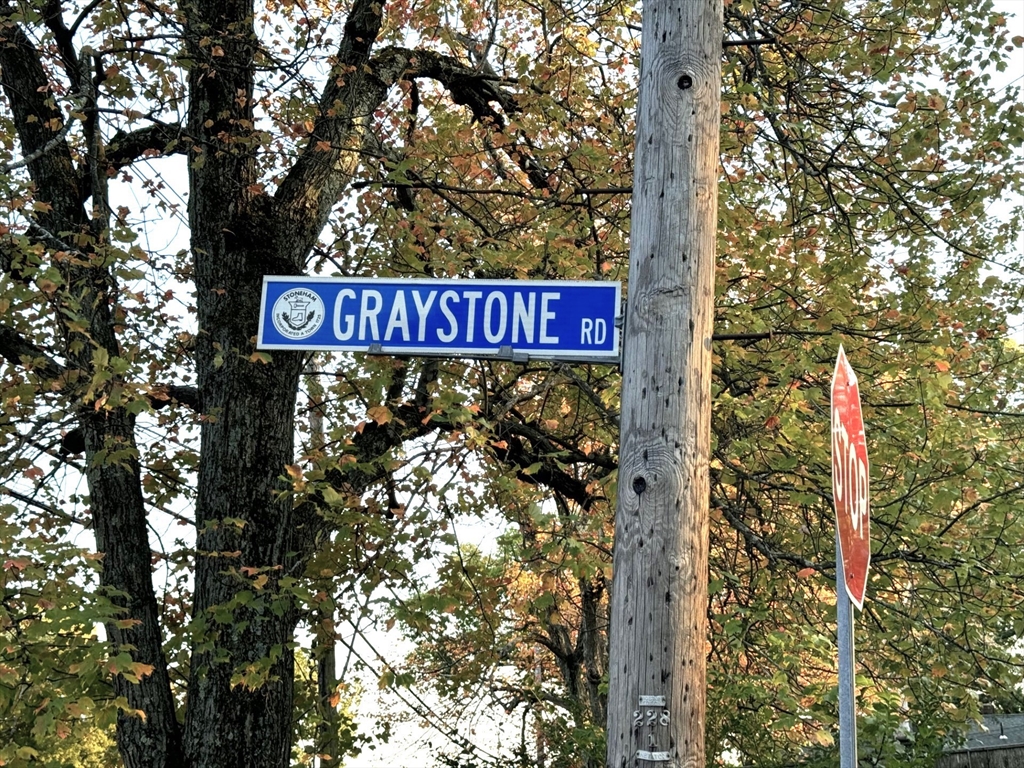 a sign board with tall trees