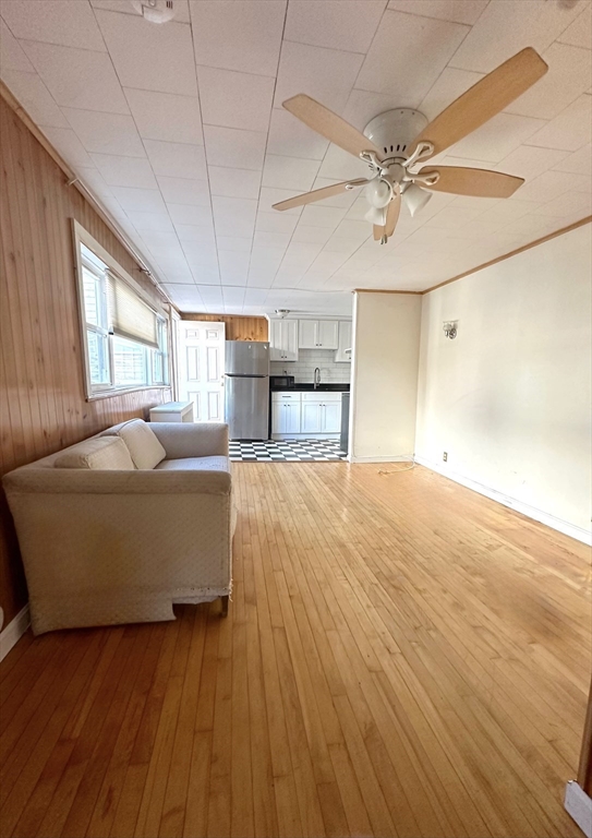 a living room with kitchen island granite countertop wooden floor and a fireplace