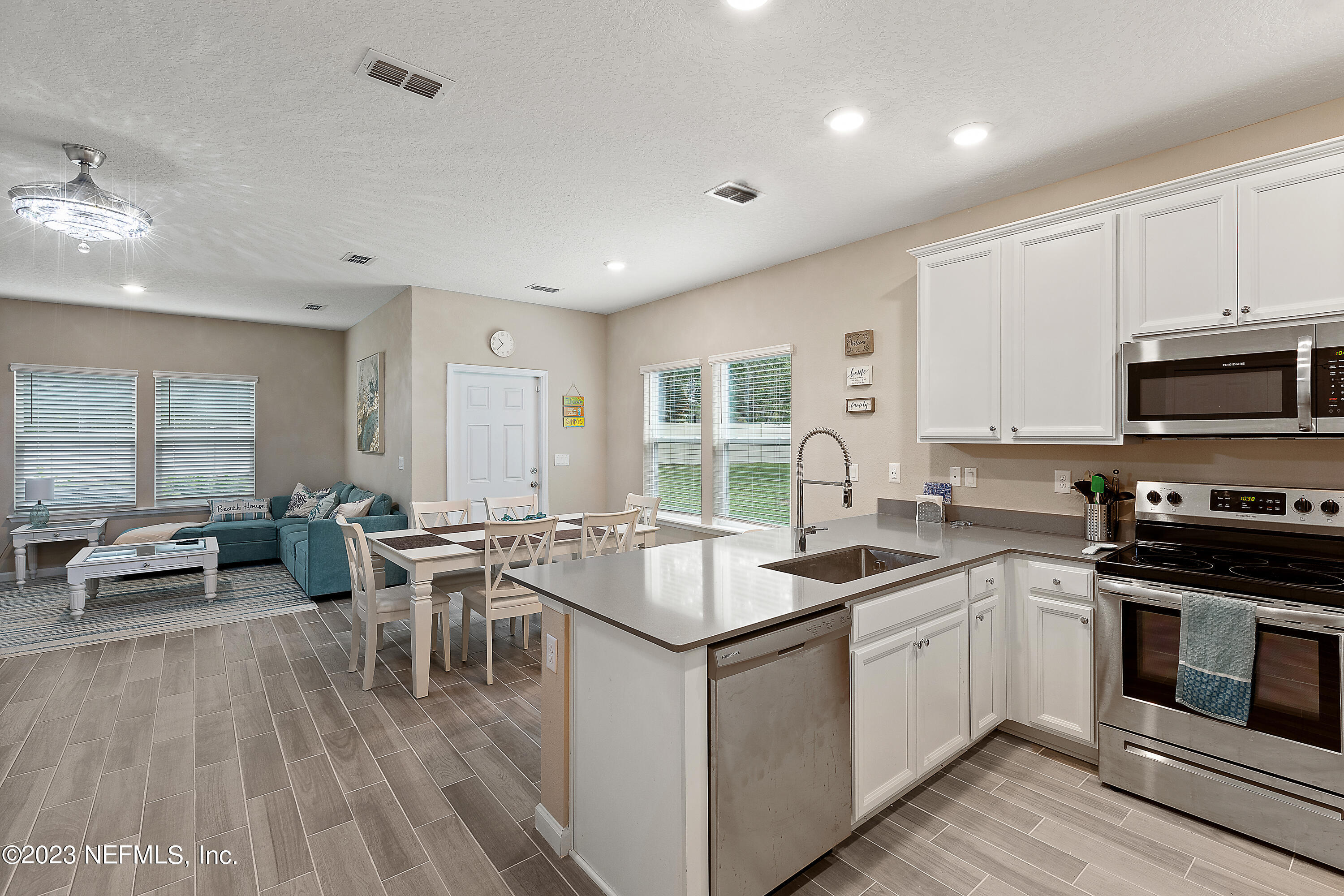 a kitchen that has a sink and a stove with white cabinets