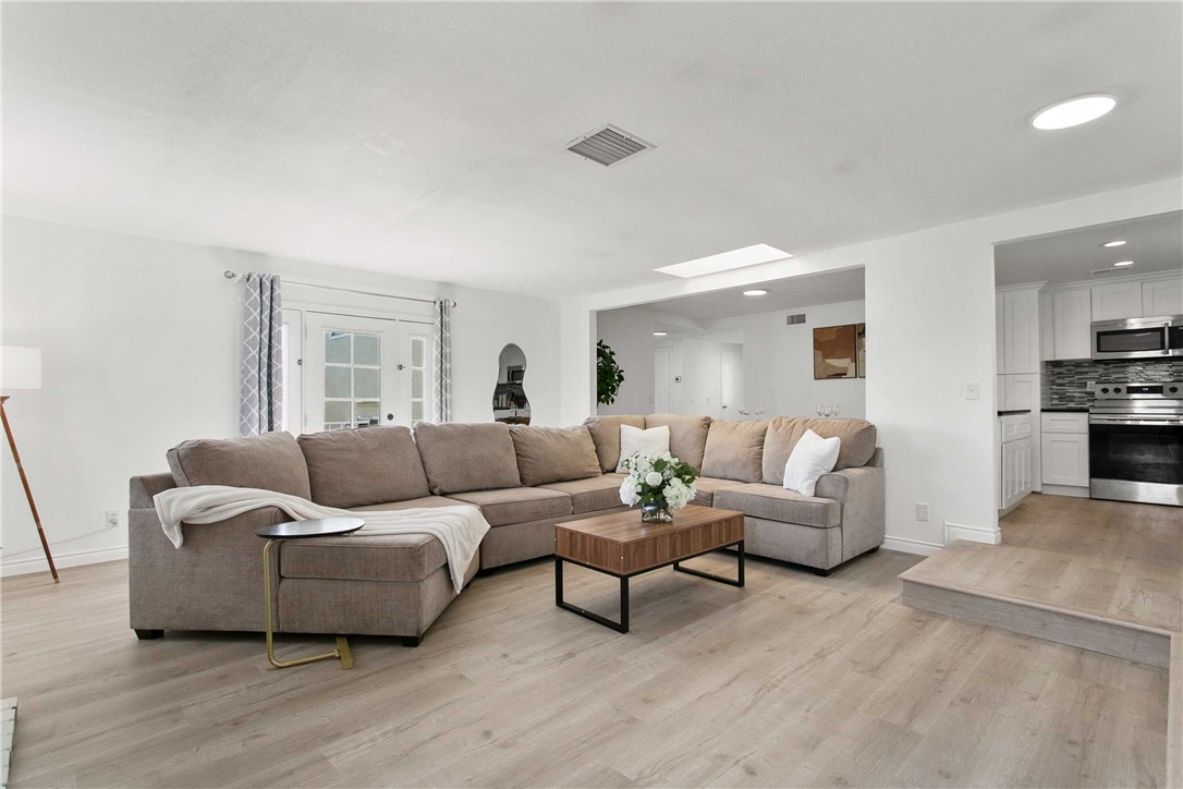 a living room with furniture and view of kitchen