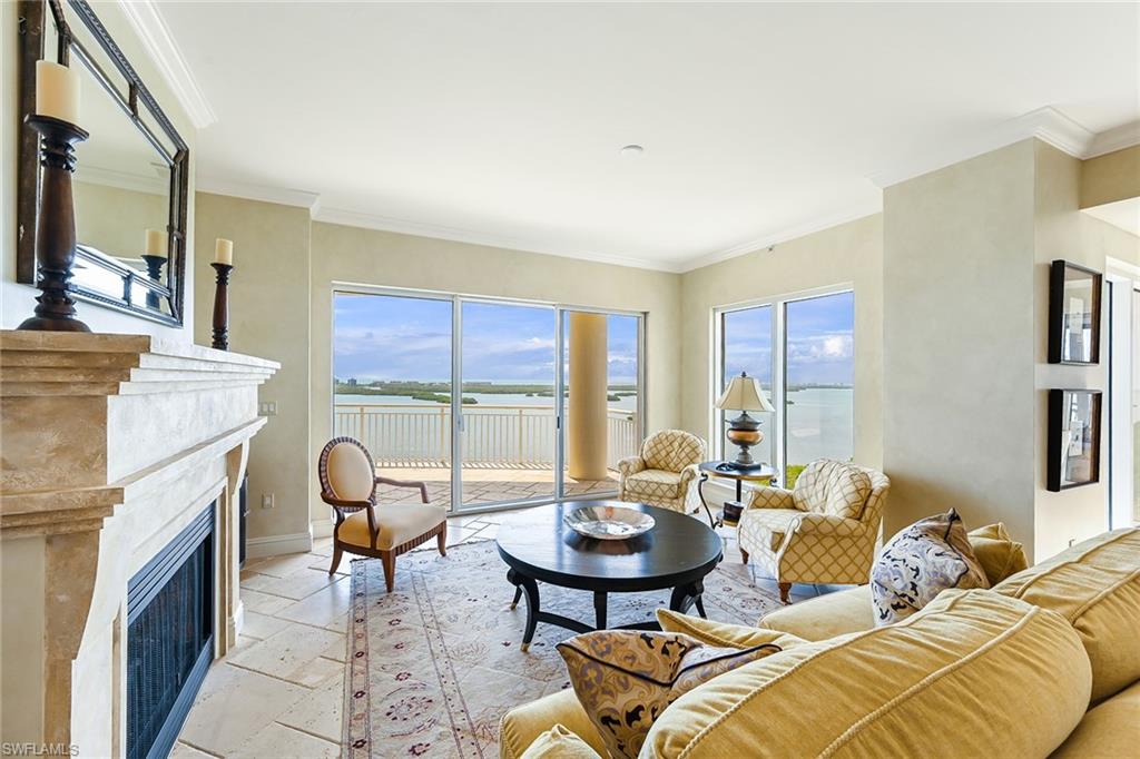 a living room with furniture a fireplace and a large window