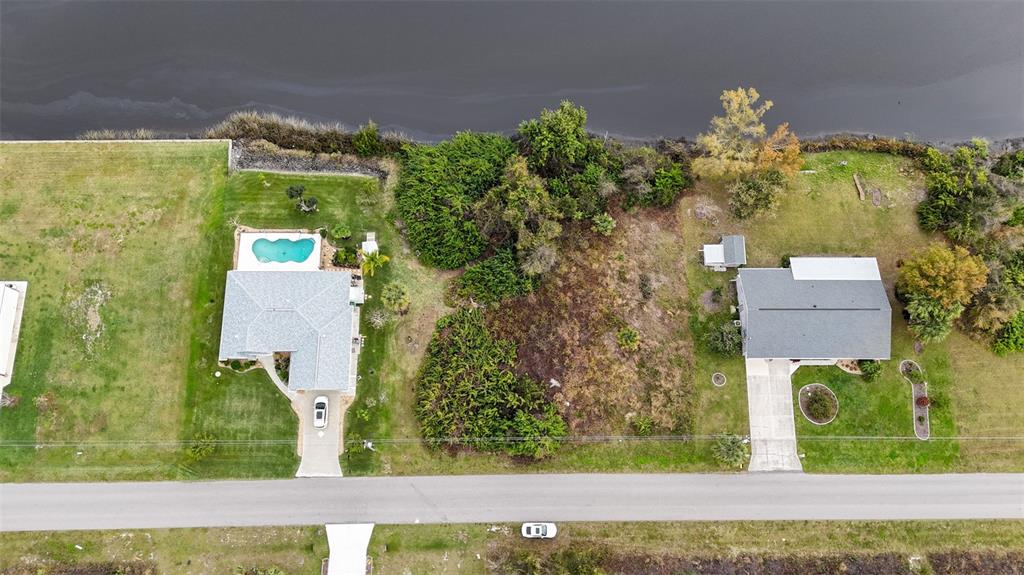 an aerial view of a residential houses with yard