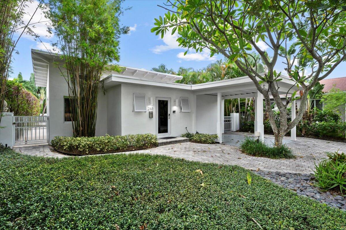 a front view of a house with a garden and yard