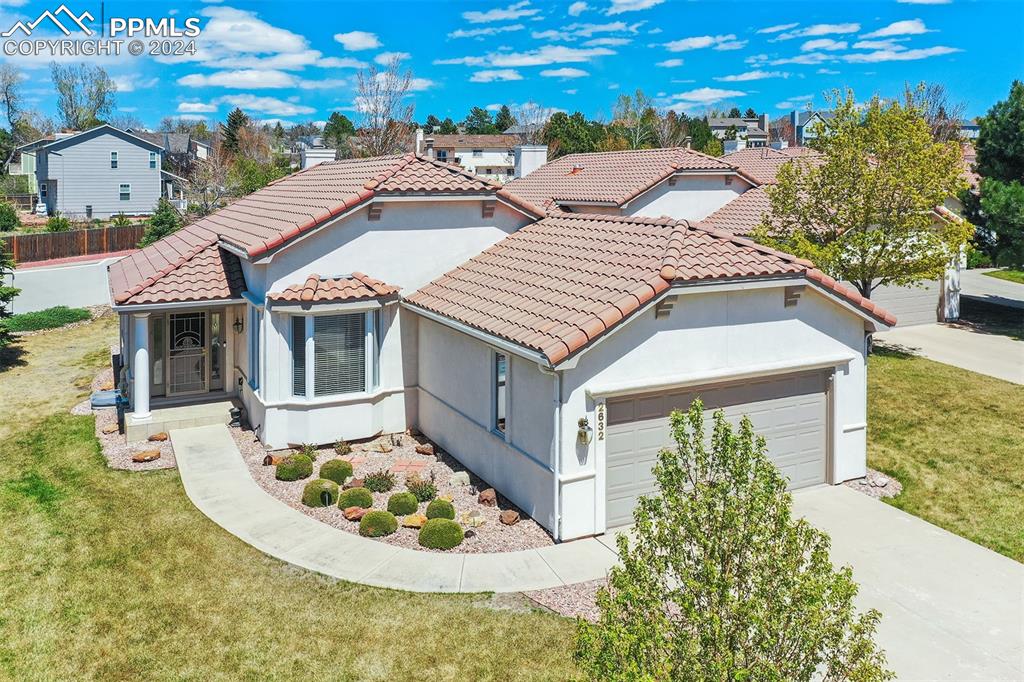 a aerial view of a house with a yard and potted plants