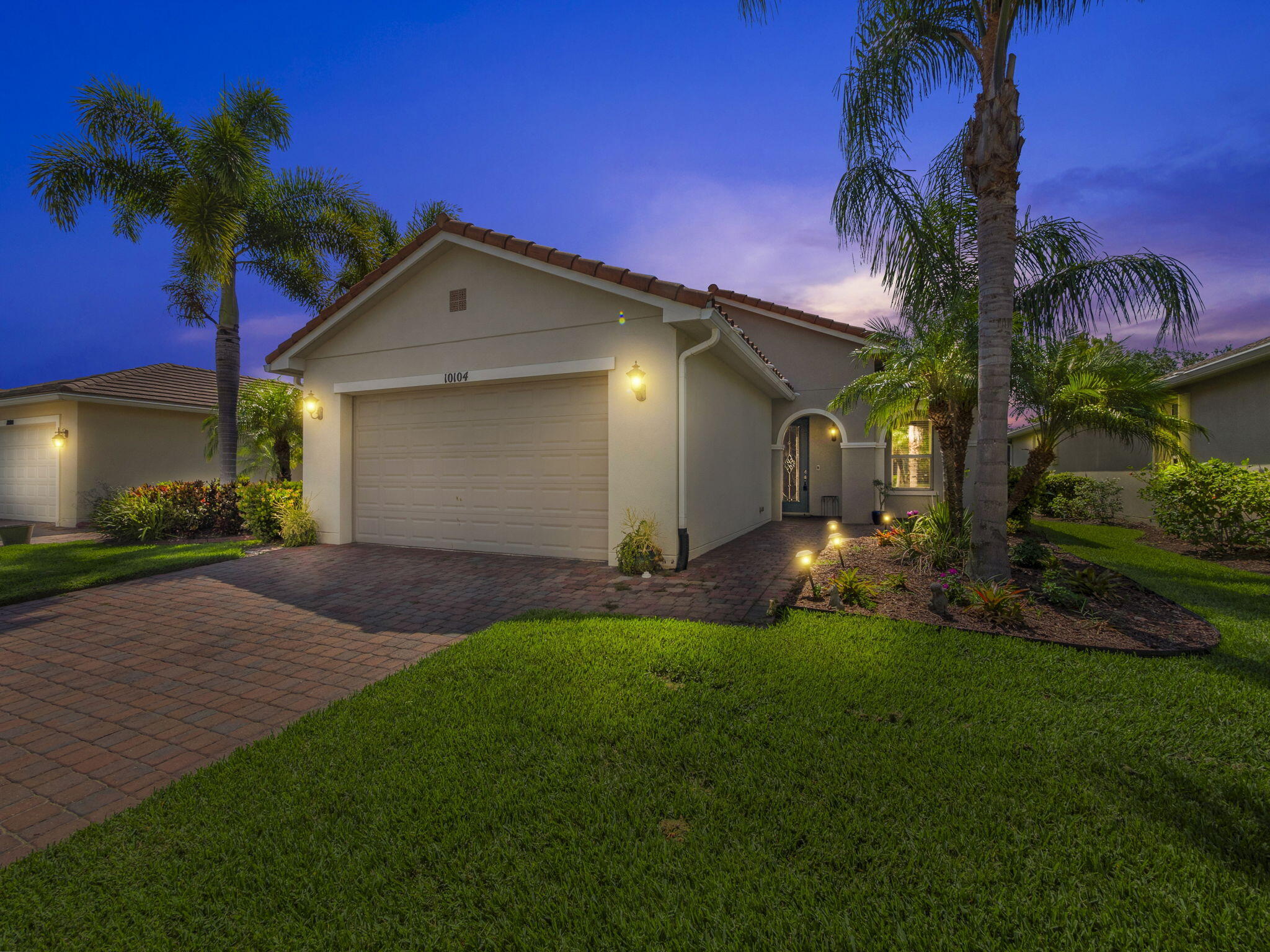 a view of a house with a yard and palm tree