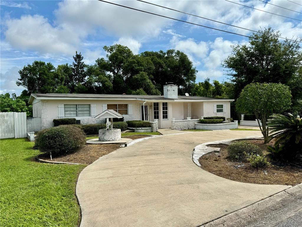 a view of a house with backyard and sitting area