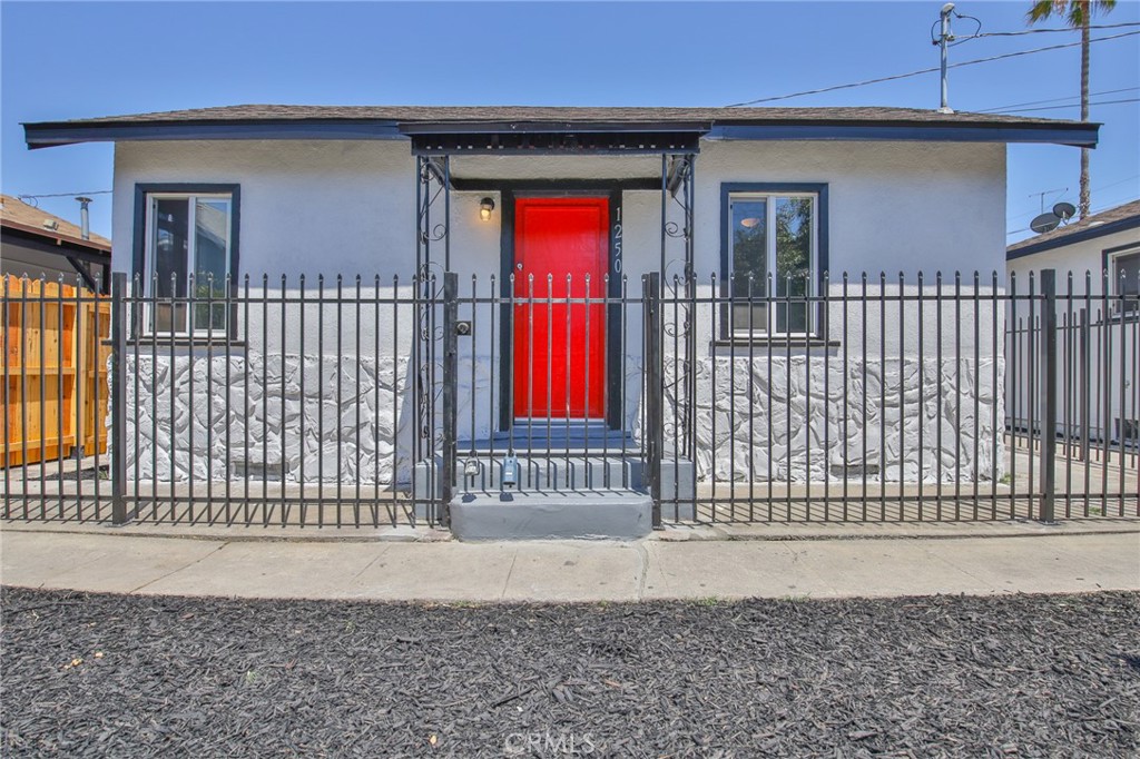 a view of a house with a small yard and wooden fence