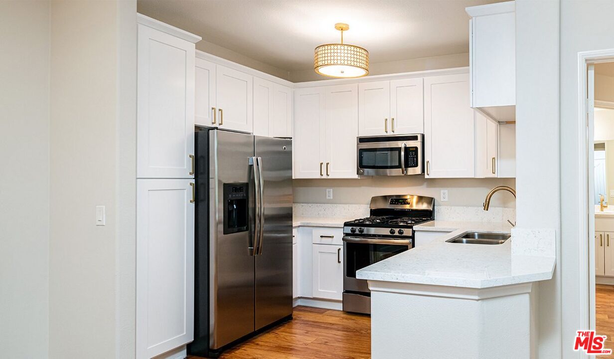 a kitchen with a refrigerator a stove and a microwave