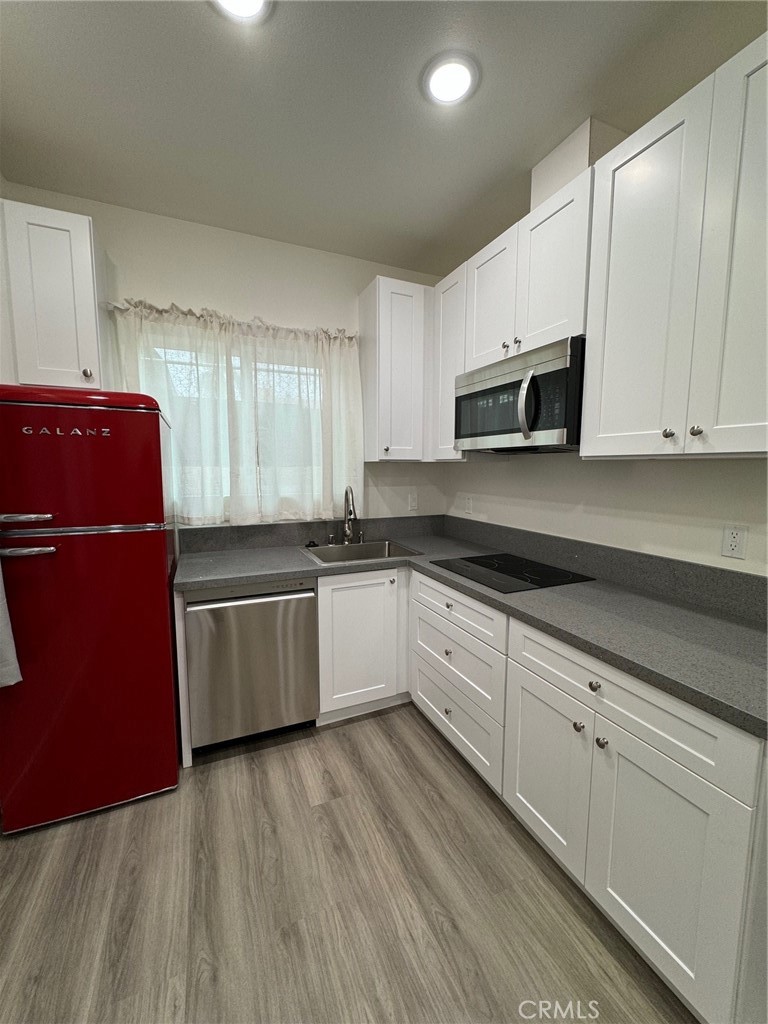 a kitchen with sink a microwave and cabinets