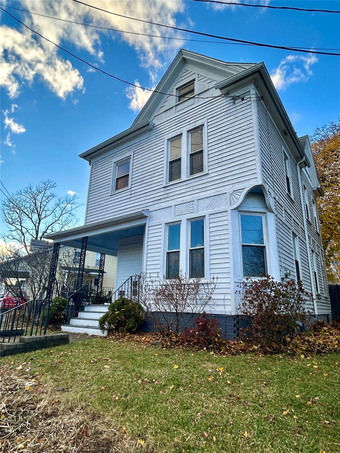 View of front of property featuring covered porch and a front yard