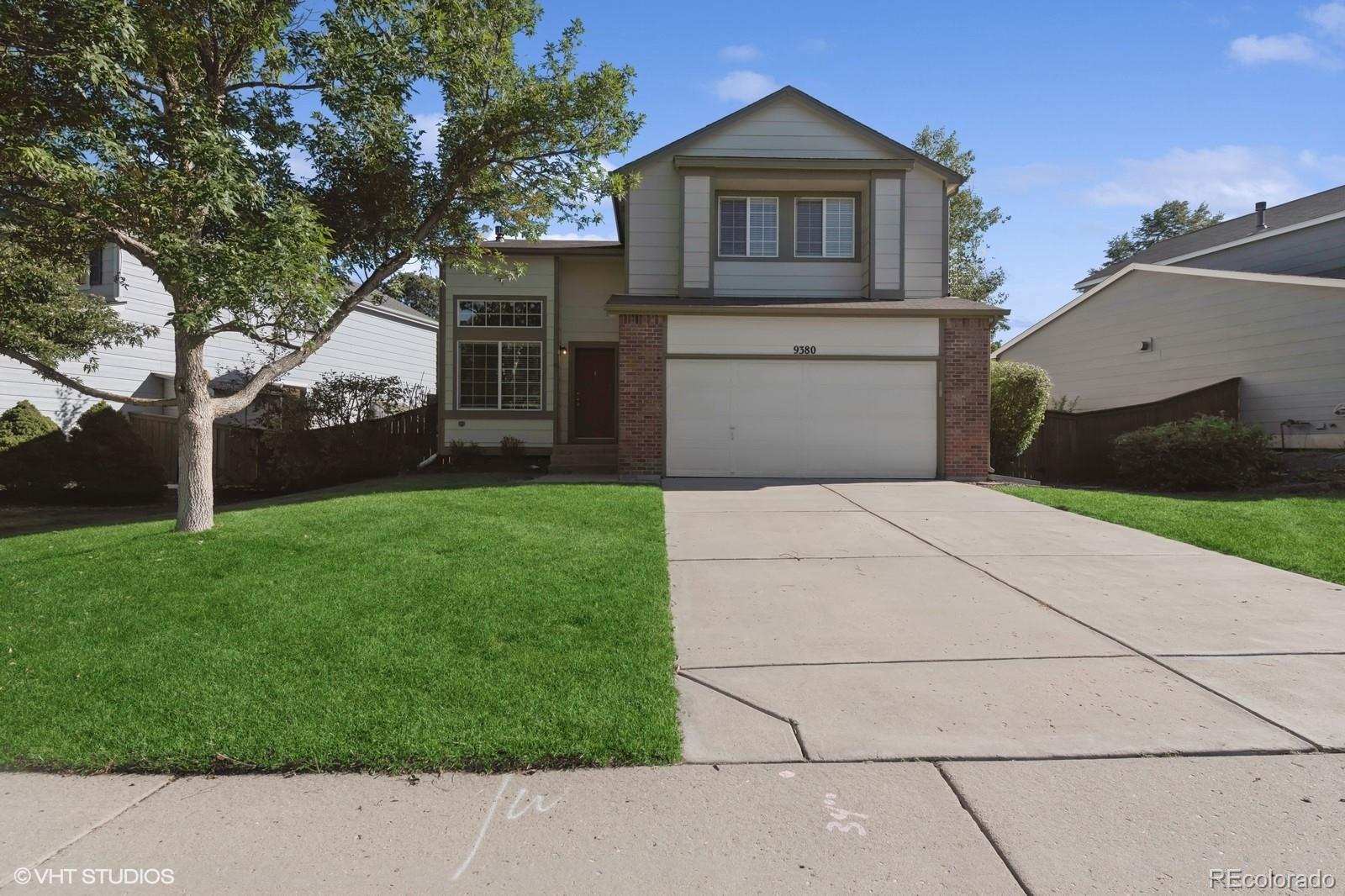 a front view of house with yard and green space