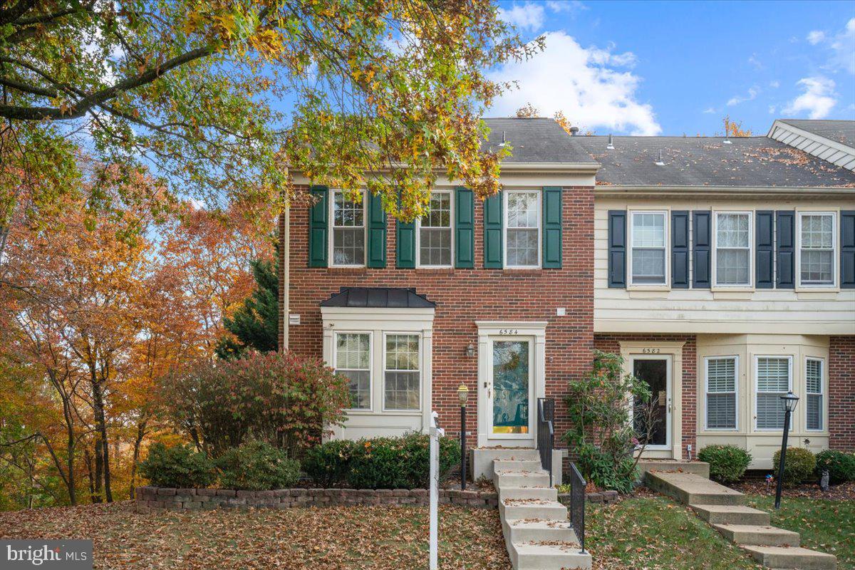 front view of a brick house with a yard