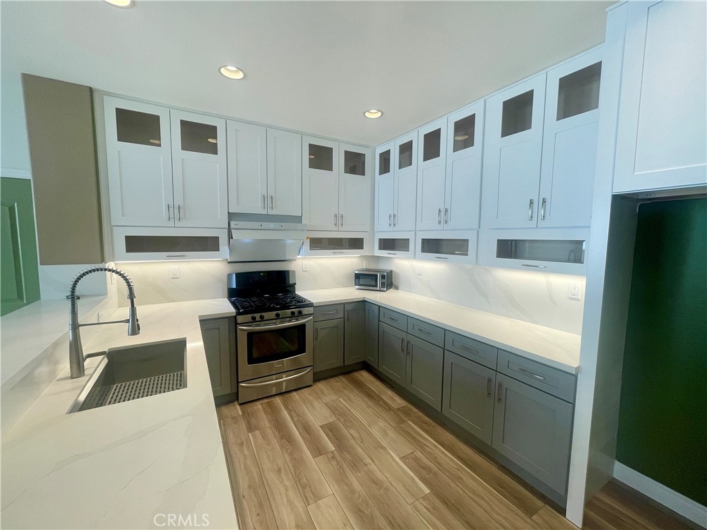 a kitchen with kitchen island granite countertop a stove and a sink