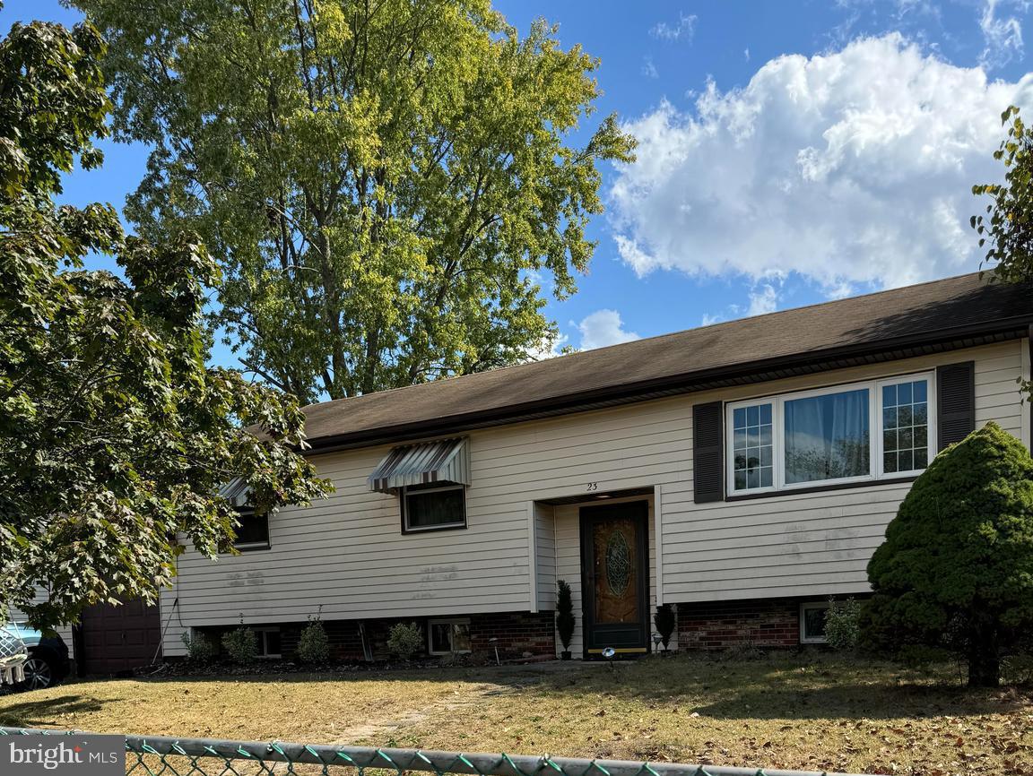 a front view of a house with a tree