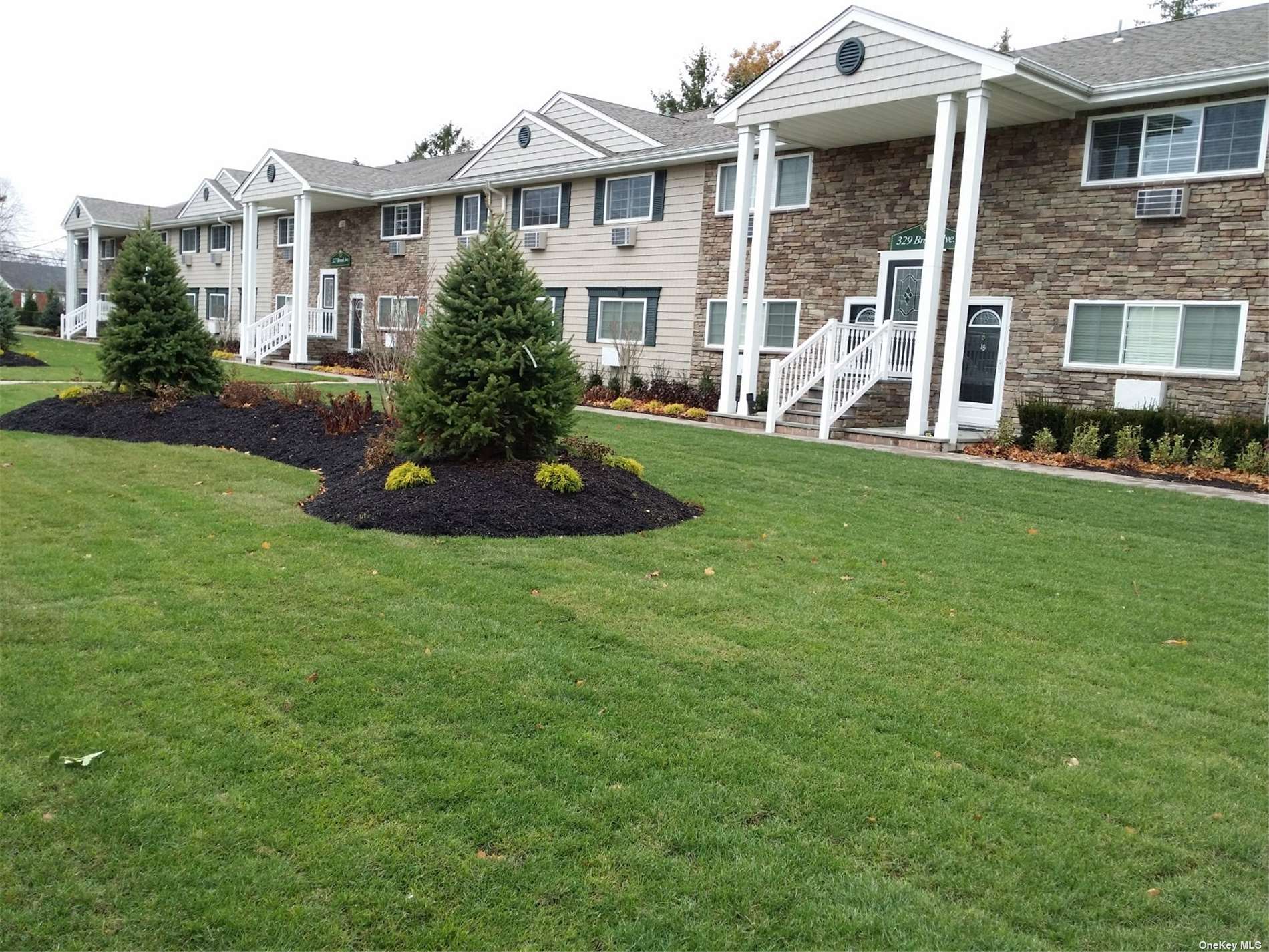 a front view of a house with a yard and potted plants