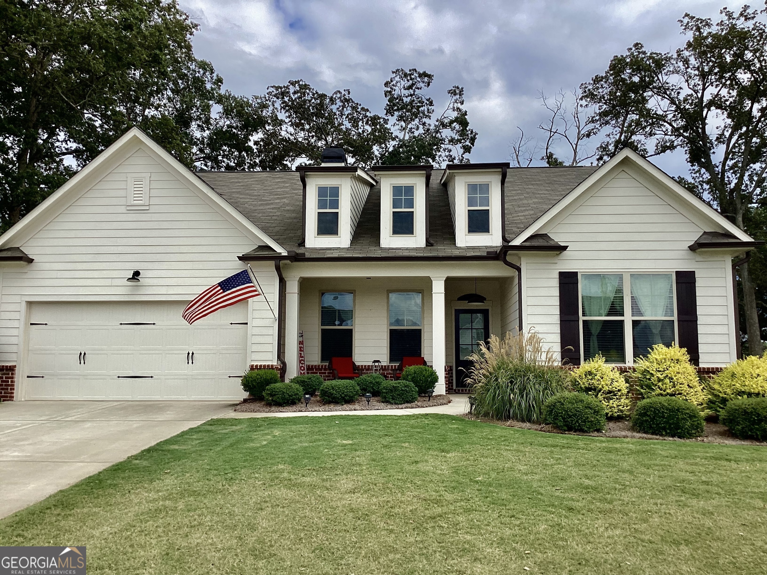 a front view of a house with a yard and trees