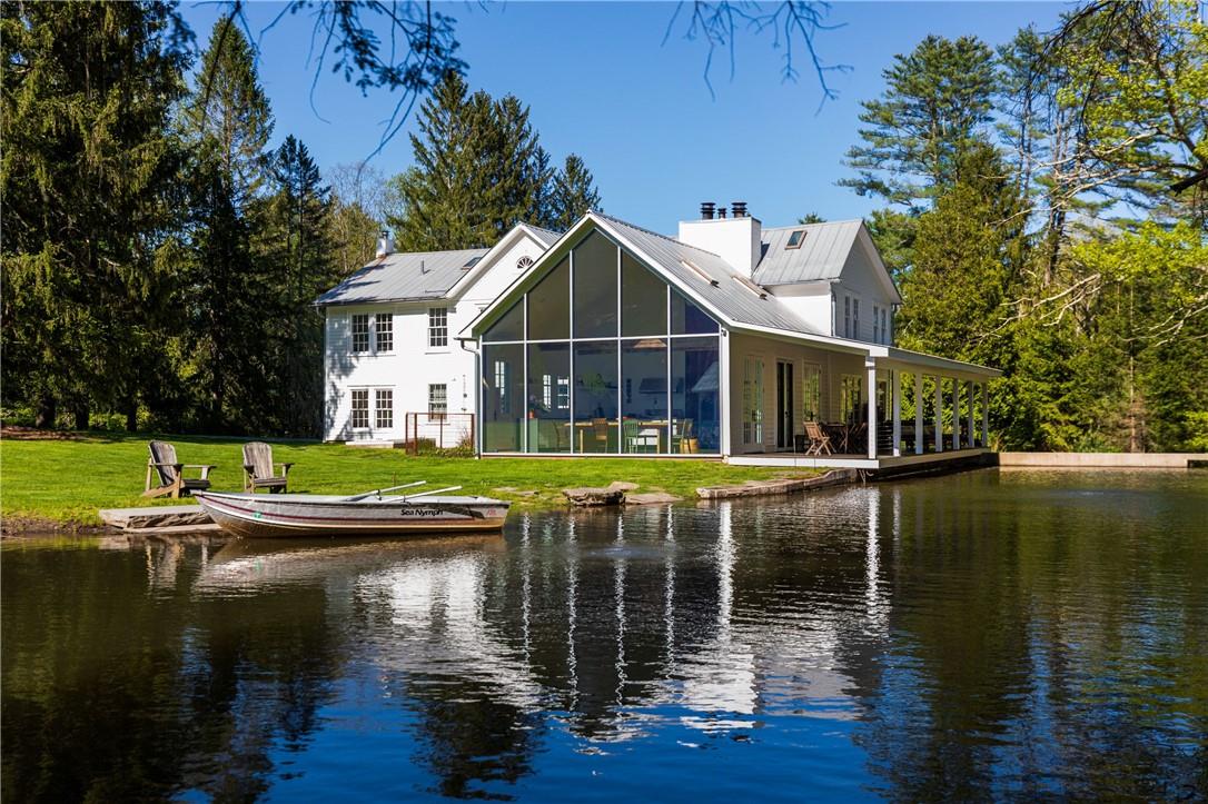 a view of house with swimming pool next to a yard