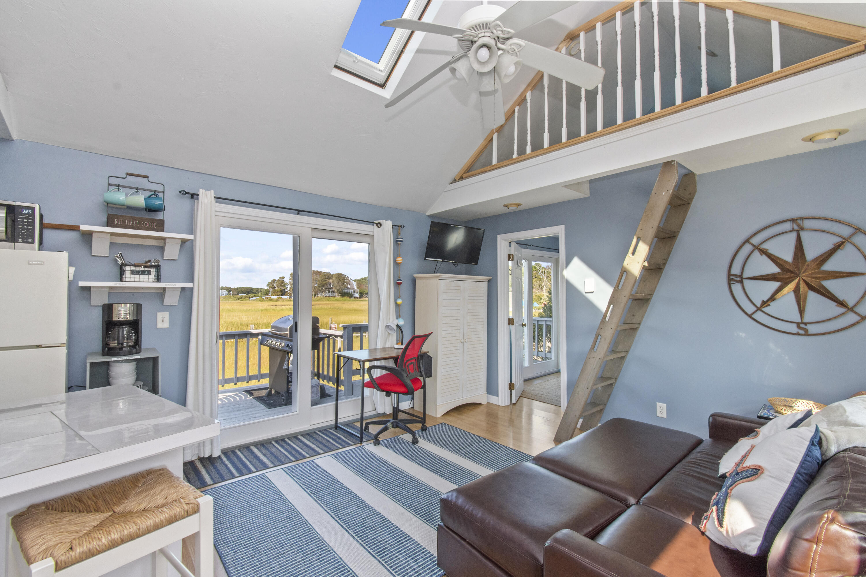 a living room with furniture a flat screen tv and a floor to ceiling window