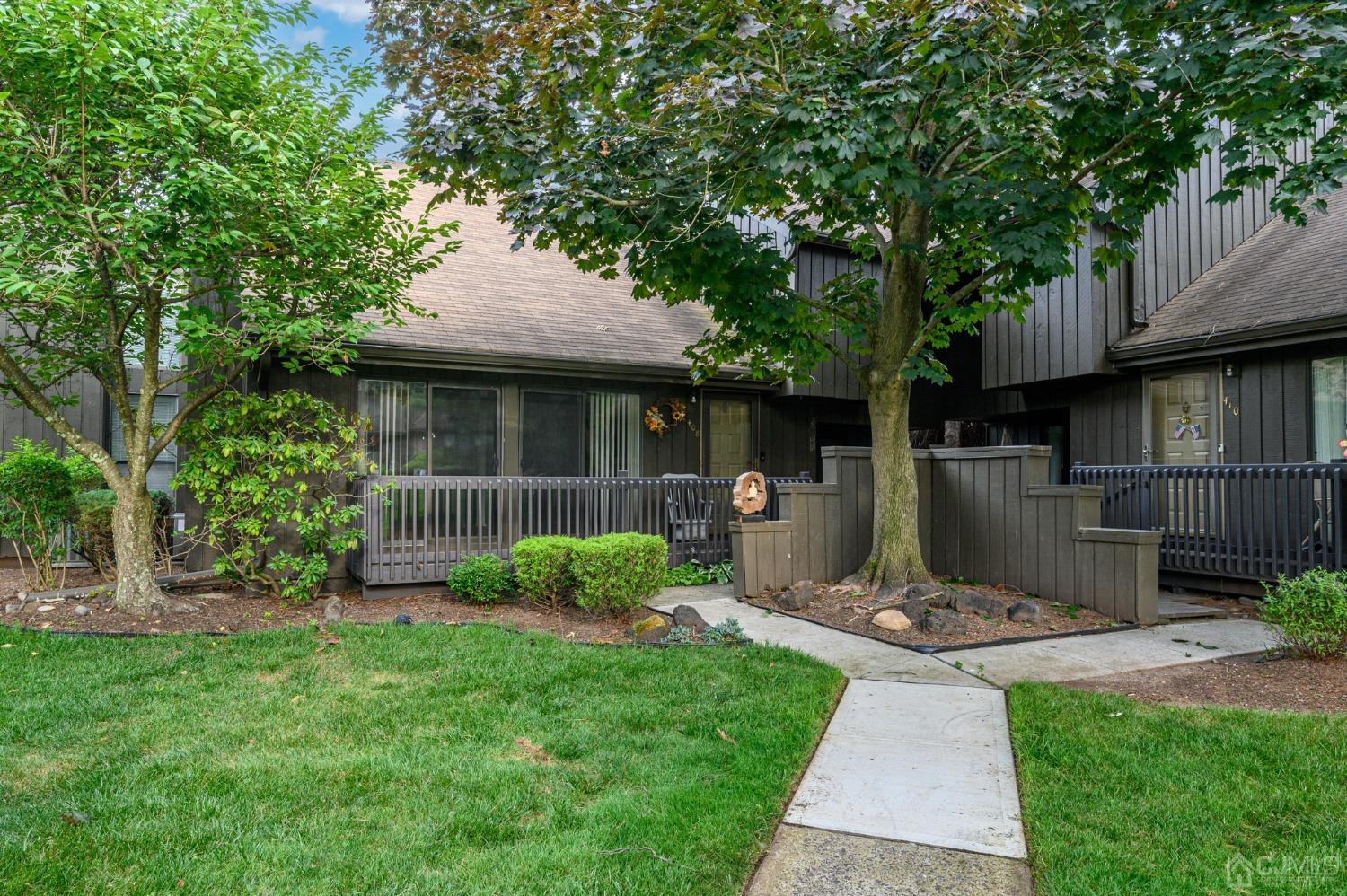 a front view of a house with garden and yard