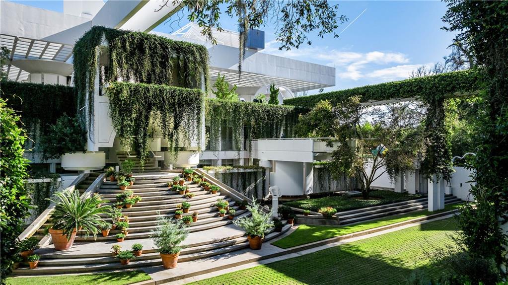 a view of a swimming pool with sitting area and garden