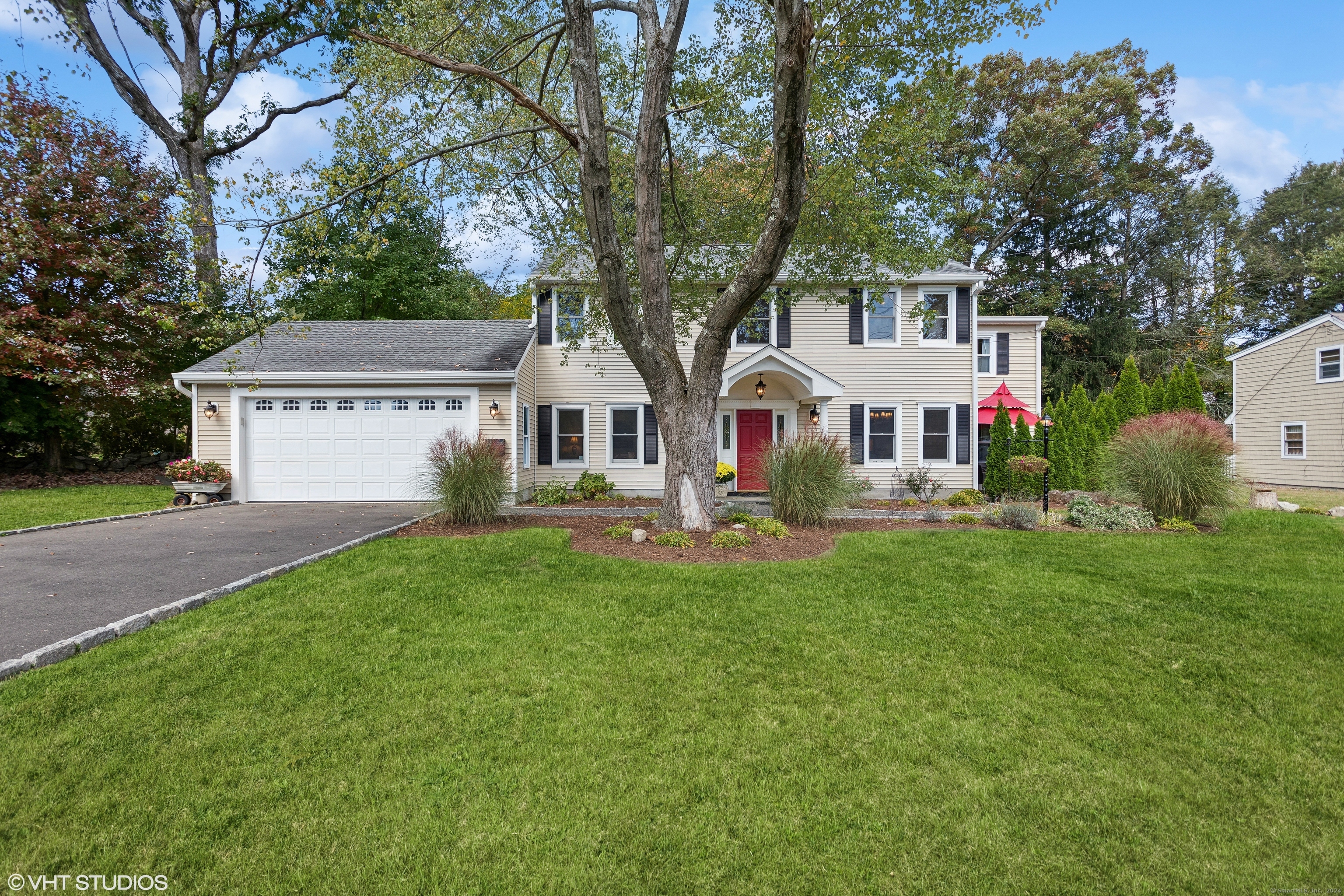 a view of white house with yard and tree s