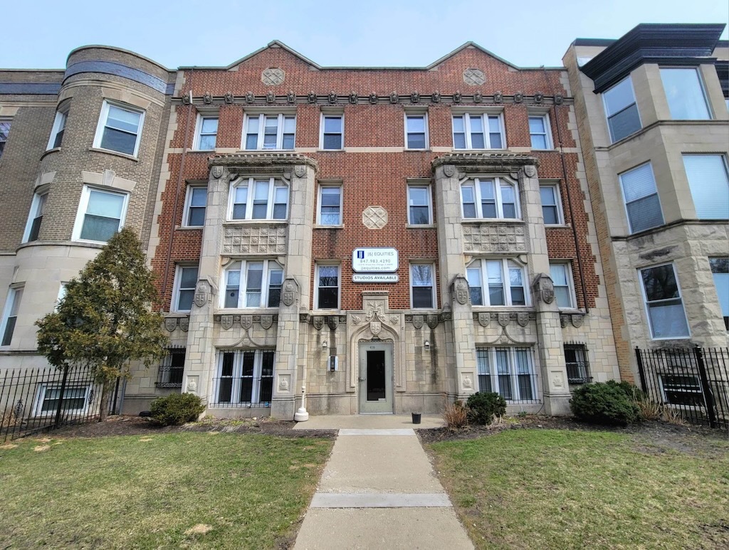 a front view of a residential apartment building with a yard