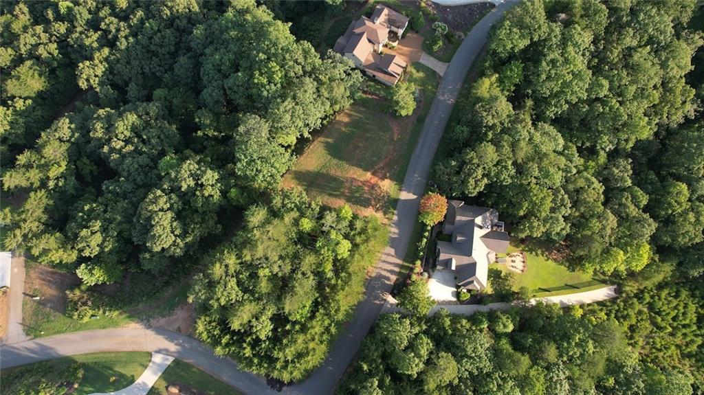 an aerial view of residential house with outdoor space and trees all around