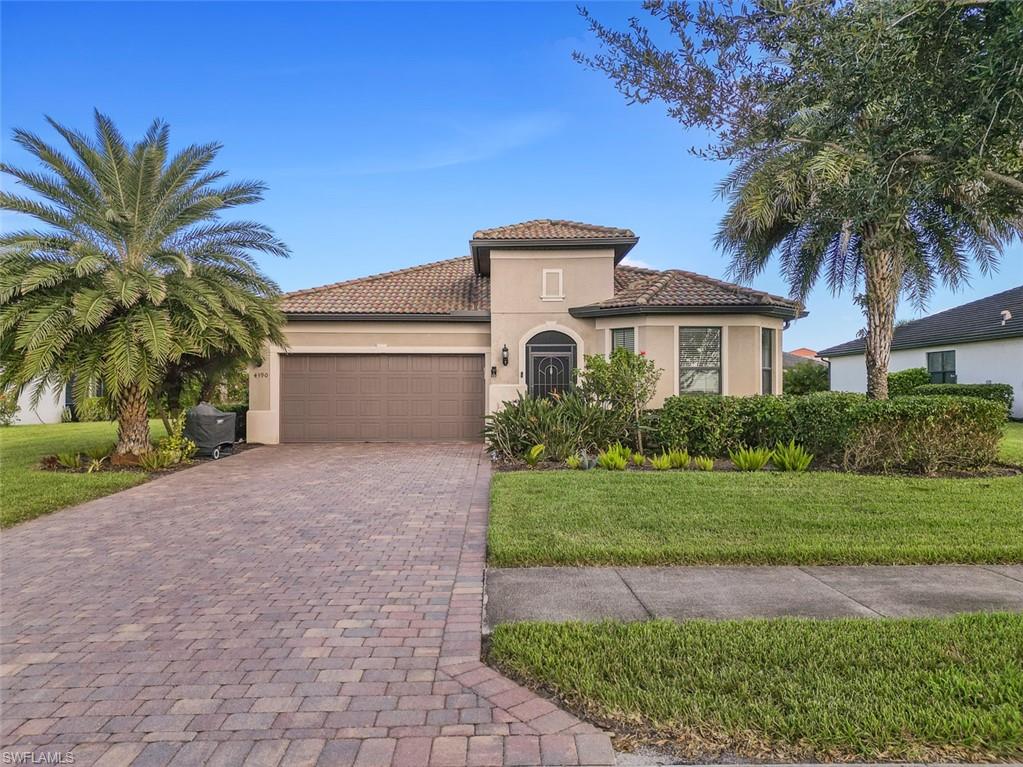 Mediterranean / spanish home with a garage and a front lawn