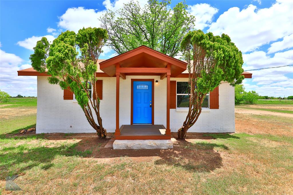 a view of a small house with a yard