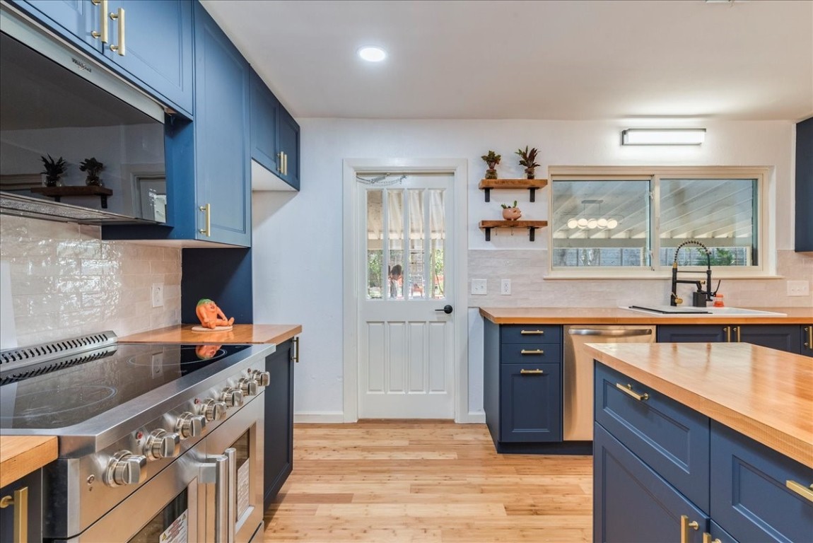 a kitchen with stainless steel appliances granite countertop a sink and stove