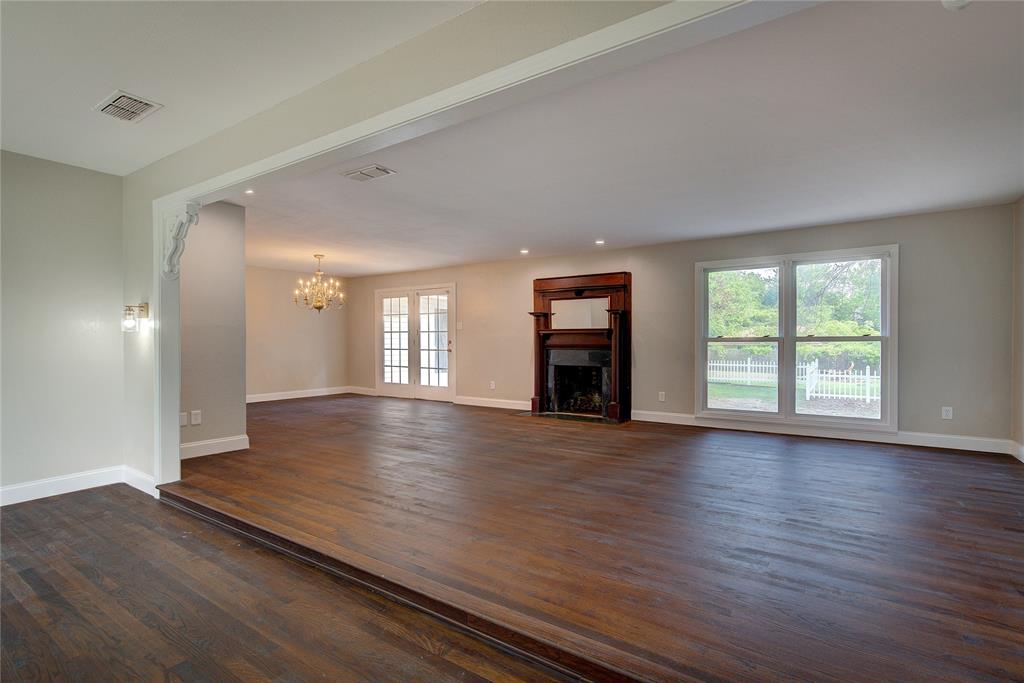 Unfurnished living room with a chandelier, french doors, and dark hardwood / wood-style flooring