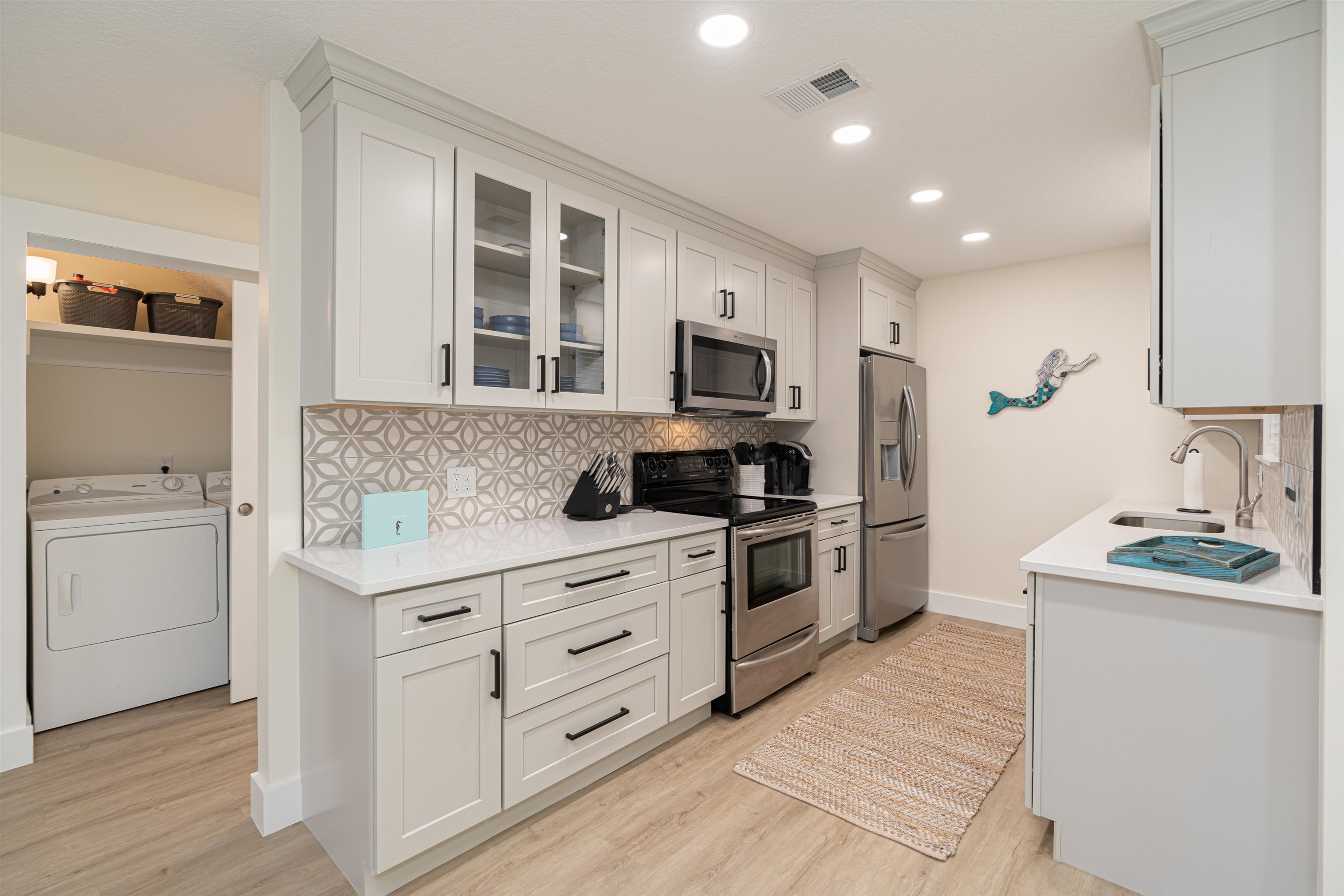 a kitchen with granite countertop a sink stove and refrigerator