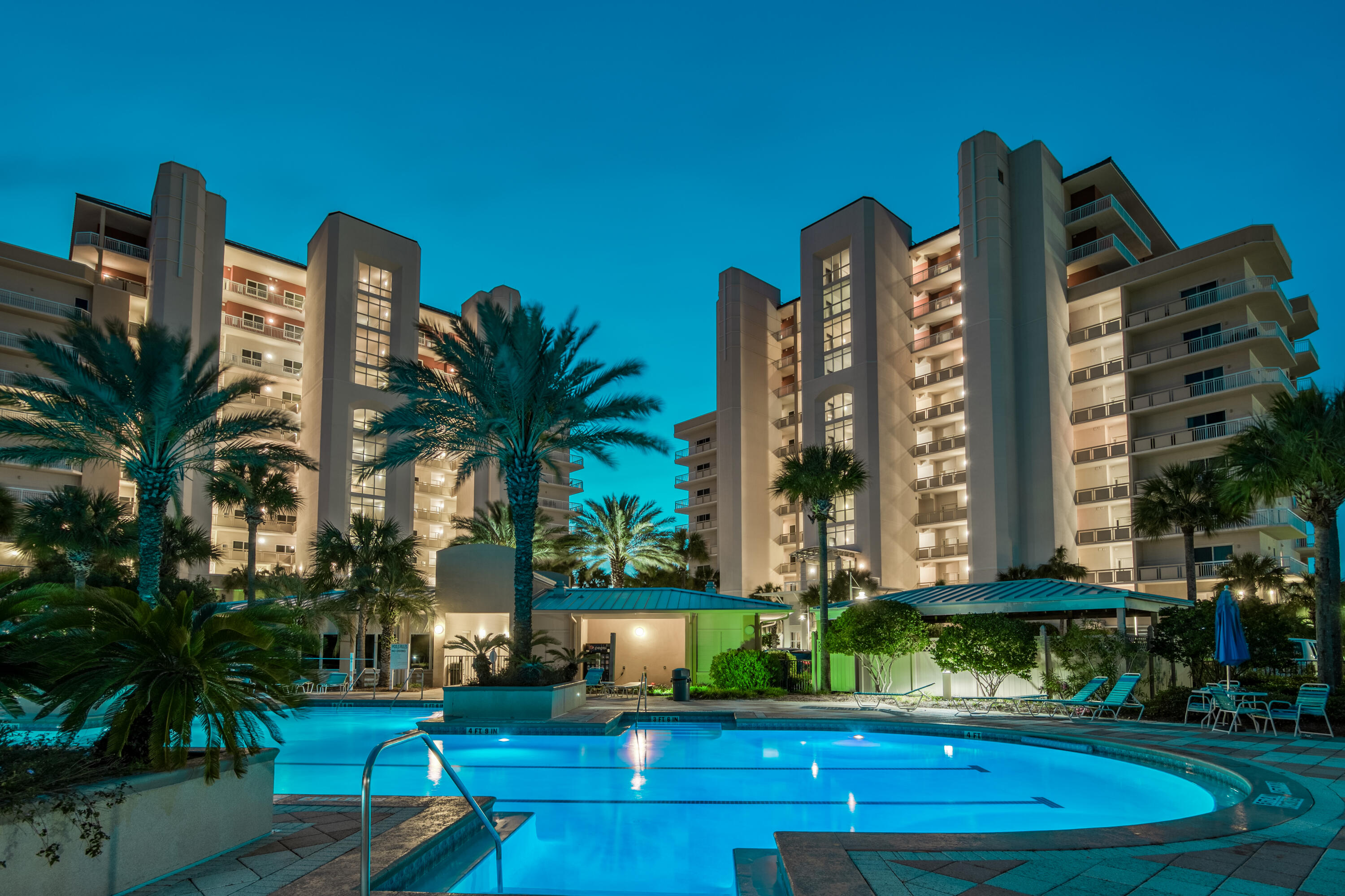 a front view of multi story residential apartment building with yard and outdoor seating