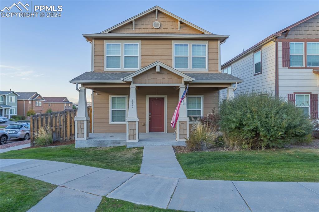 Craftsman-style home featuring covered porch and a front lawn