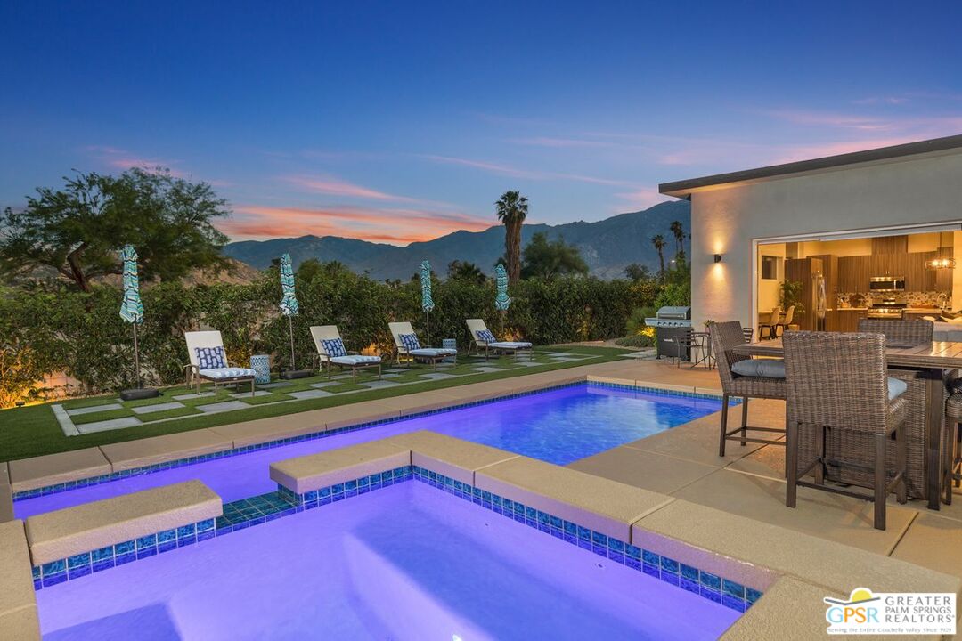 a view of swimming pool with outdoor seating and city view