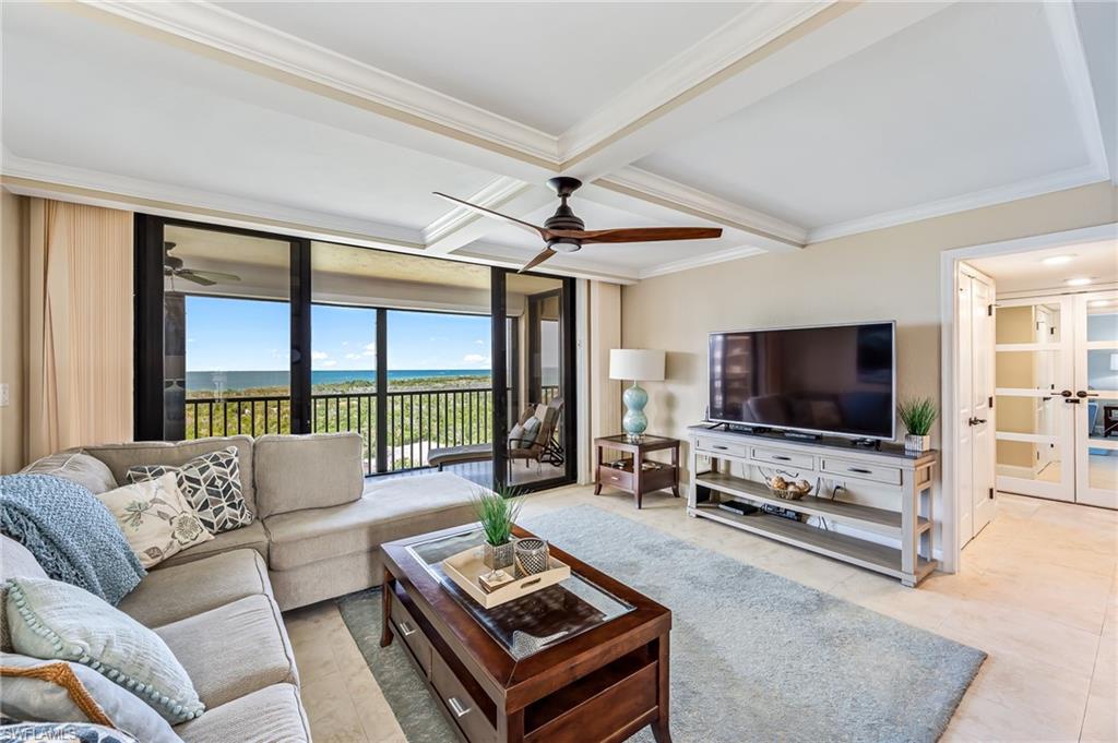 a living room with furniture a flat screen tv and a large window