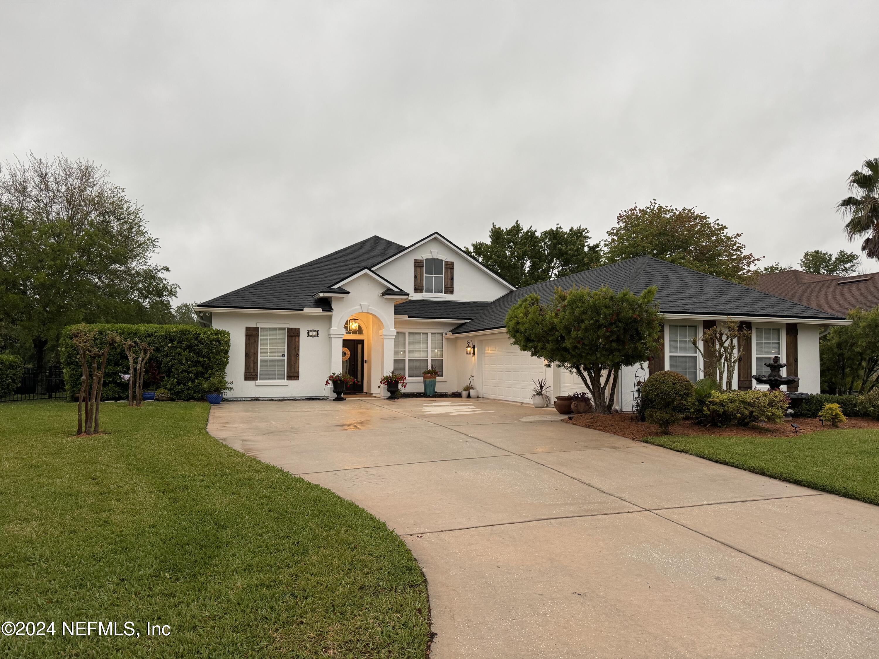 a front view of a house with a yard and trees