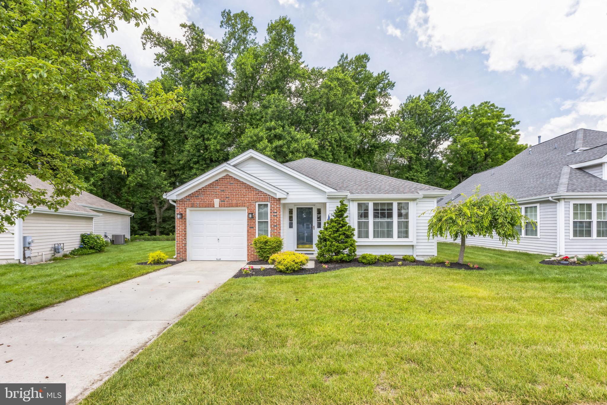 a front view of a house with a yard and trees