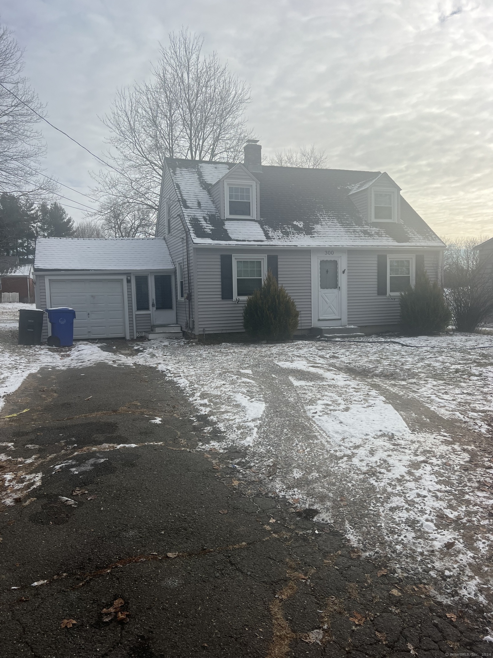 a front view of house with yard and trees in the background