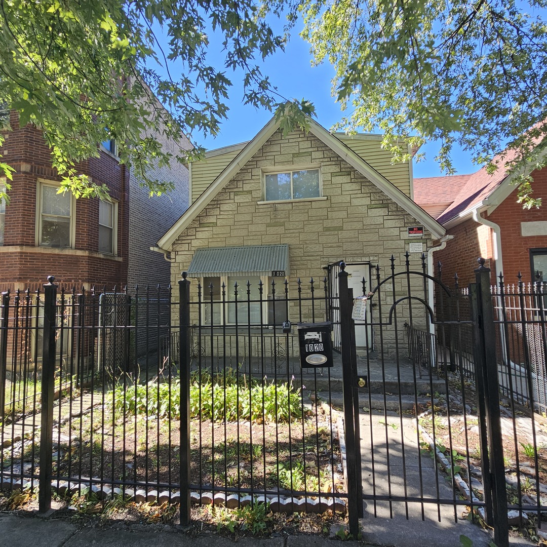 a front view of a house with a iron fence